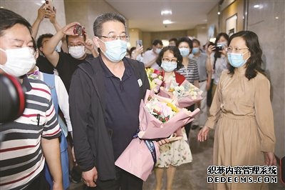 新冠肺炎疫情暴發(fā)后，中央指導(dǎo)組專家組成員，東南大學(xué)附屬中大醫(yī)院黨委副書記、紀(jì)委書記、主任醫(yī)師邱海波四度出征，先后轉(zhuǎn)戰(zhàn)湖北、黑龍江、吉林、新疆等地，在抗疫一線鏖戰(zhàn)185天。圖為6月5日，邱海波從吉林返回南京，在機(jī)場受到熱烈歡迎。（圖片來源：視覺中國）