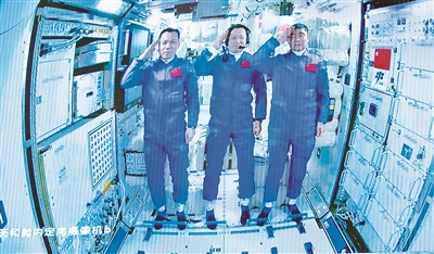 圖為6月17日在北京航天飛行控制中心拍攝的進(jìn)駐天和核心艙的航天員向全國人民敬禮致意的畫面。 新華社記者 金立旺 攝